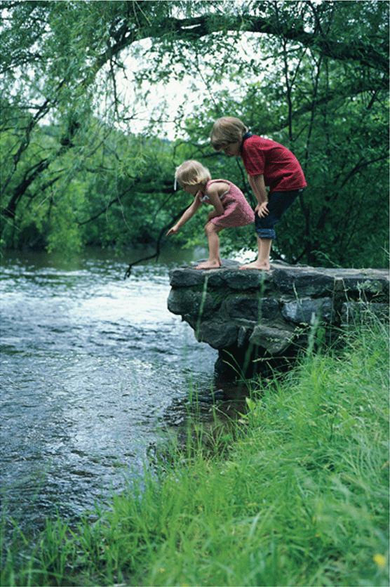 Children jumping in a stream