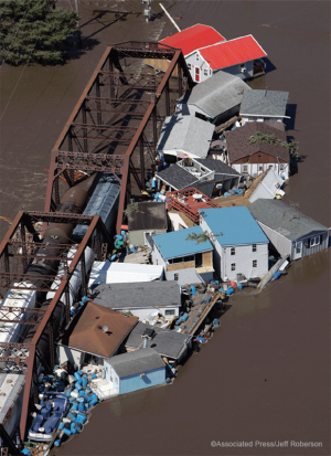 Buildings and debris float up against a railroad bridge on the Cedar River during record flooding in June 2008, in Cedar Rapids, Iowa.